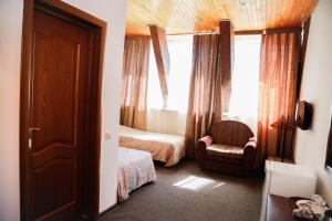 アルティバシュにあるHotel Artybashのベッドルーム1室(ベッド1台、椅子、窓付)