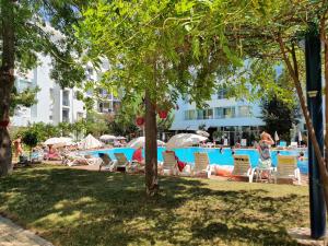 a swimming pool with lounge chairs and a hotel at Yassen Holiday Village in Sunny Beach