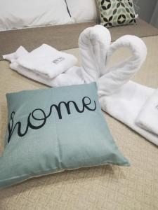 un letto con asciugamani e un cuscino con la parola coinquilina di Vacanze HOME a Caltanissetta