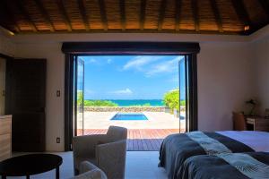 um quarto com uma cama e vista para uma piscina em Villabu Resort em Ilhas Miyako