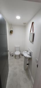 een witte badkamer met een toilet en een wastafel bij Spa House Retreat in Whitby