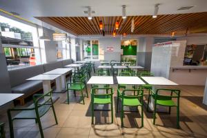 a dining room with tables and green chairs at 612КМ in Stryi