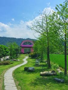 einen Gehweg, der zu einem rosa Gebäude führt in der Unterkunft Sunday Homestay in Dongshan