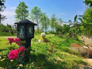 a black lantern in a garden with pink flowers at Sunday Homestay in Dongshan
