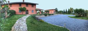 une maison avec un chemin en pierre à côté d'une maison dans l'établissement Casale Appia, à Latina