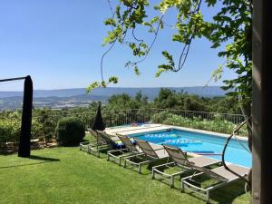 a swimming pool with lounge chairs in a yard at Mas La Bellevue in Murs