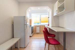 eine Küche mit einem Kühlschrank und 2 roten Stühlen in der Unterkunft Luna Rosie in Deva