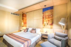 Habitación de hotel con cama y silla en Grand Plaza Hotel - Takhasosi Riyadh, en Riad