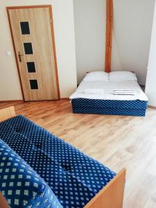 Een bed of bedden in een kamer bij Zajazd Dolina Sadosiów