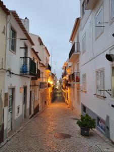 an empty street in an old town at sunset at A Casa dos Avós in Nazaré