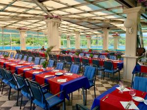 een rij tafels en stoelen met rood en blauw tafelkleed bij Villa Koruna - Mali Ston in Ston