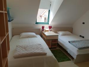 two beds in a small room with a window at Dolac Guesthouse in Zagreb