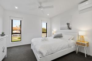 - une chambre blanche avec un lit et une fenêtre dans l'établissement TORQUAY Relax and Unwind Beach 300m Table Tennis, à Torquay