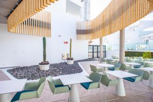 a cafeteria with tables and chairs in a building at Hotel Taimar in Costa Calma