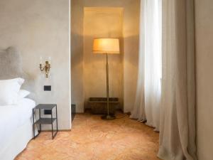 Postel nebo postele na pokoji v ubytování Palazzo Albricci Peregrini