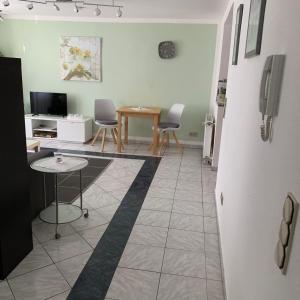 ein Wohnzimmer mit einem Tisch und Stühlen sowie einem Kühlschrank in der Unterkunft Ferienwohnung „ Zum Josefstal „ in Sankt Ingbert