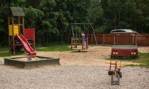 um parque infantil com dois baloiços e um escorrega em Pensjonat Cyrkon em Iwaniska