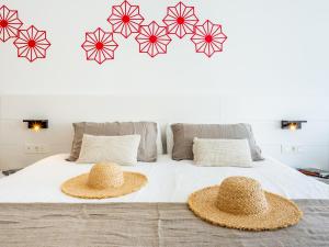 two straw hats sitting on top of a bed at Hotel Taimar in Costa Calma