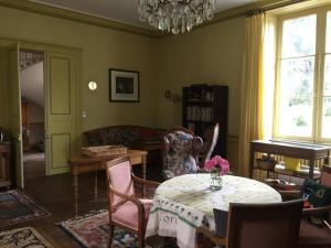 a living room with a table and a chandelier at Château de Pintray in Lussault-sur-Loire