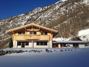 un edificio en la nieve frente a una montaña en Santerhof, en Sölden