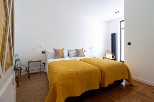 サン・セバスティアンにあるBella Easo - Iberorent Apartmentsのベッドルーム1室(大型ベッド1台、黄色い毛布付)