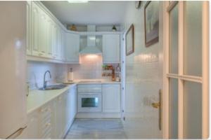 a white kitchen with a sink and a stove at Mi Capricho in Sitio de Calahonda