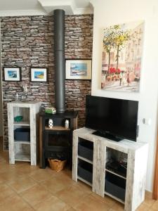 een woonkamer met een open haard en een flatscreen-tv bij Casa Carmela in Burgau