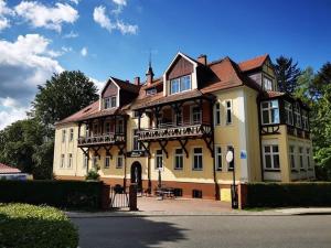 a large yellow house with a gambrel roof at Willa Diament in Kudowa-Zdrój