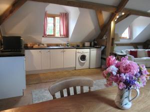 a kitchen with a table with a vase of flowers at Wooden Cabbage Barn in Dorchester