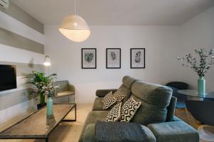 sala de estar con sofá y mesa en Magno Apartments Encarnación, en Sevilla