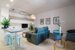 sala de estar con sofá azul y mesa en Magno Apartments Encarnación, en Sevilla