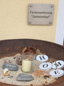 a sign with a candle and some shells on a table at Businesswohnungen Haag bei A7 in Aalen