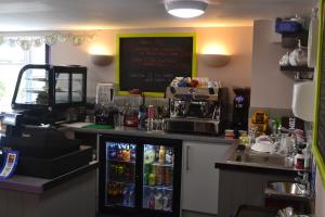 a bar in a restaurant with a counter with soda machines at The Lawns Tea Room and B&B in Ashcott