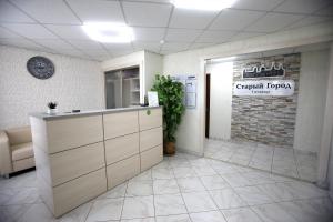 an office lobby with a counter and a plant in it at Гостиница Старый Город in Barnaul