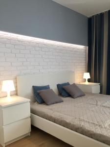 1 dormitorio con 1 cama blanca y 2 lámparas en Apartament KOPENHAGA, en Białystok