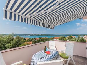 stół i krzesła na balkonie z parasolem w obiekcie Apartment F-3 Klimno w mieście Klimno