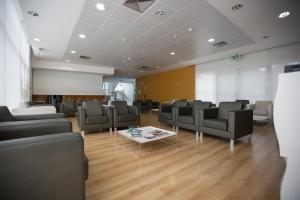 a waiting room with chairs and a table in a building at HI Lousã – Pousada de Juventude in Lousã