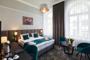 a hotel room with a bed and a table and chairs at Hotel Estera in Krakow