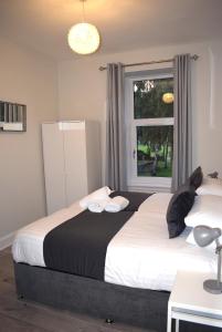 
a bedroom with a white bed and a white comforter at Kelpies Serviced Apartments- Victoria in Falkirk
