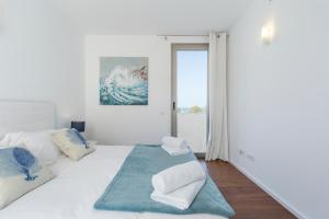 biała sypialnia z łóżkiem z poduszkami w obiekcie Modern House With Panoramic Sea View In Mallorca w mieście Son Serra de Marina