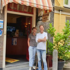 
a man and woman standing in front of a store at Hotel de Emauspoort in Delft
