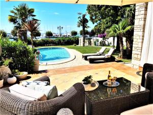 a patio with wicker chairs and a swimming pool at Villa Magnolia Umag in Umag