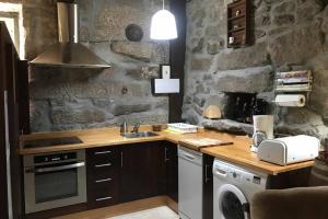 uma cozinha com um lavatório e um fogão forno superior em CASA ALBA DE SAN ROMÁN em Ourense