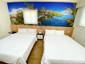 馬公市的住宿－澎湖海晴民宿，墙上画画的房间里设有两张床