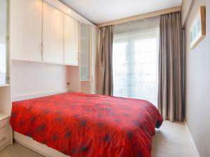 a bedroom with a red bed and a window at Simplistic Apartment in Blankenberghe near Belgium Pier in Blankenberge
