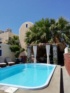 a swimming pool in a resort with palm trees at 5bedroom villa in perissa beach in Perissa