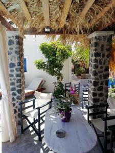 ペリッサにある5bedroom villa in perissa beachのパティオ(椅子、鉢植えの植物付きテーブル付)