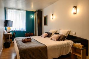 Postel nebo postele na pokoji v ubytování Hôtel Le Bayeux + 37 fotografií