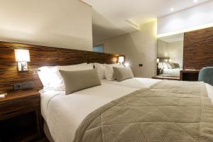 a hotel room with a large bed and a desk at Nour Plazza Hotel in Fez