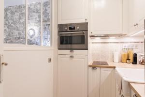 cocina blanca con armarios blancos y microondas en The French Boudoir, en Épernay